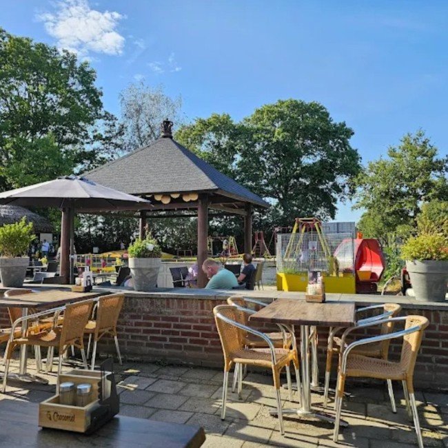 Het terras van Klein Amerika met het rieten prieel op een zonnige dag